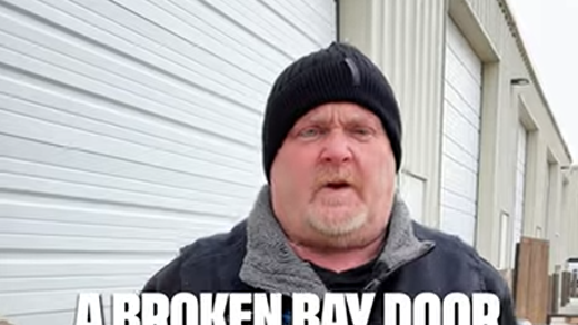 A man in a hat standing in front of a garage door